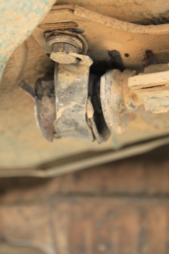 The rusted through original bracket and a questionable Mongolian bracket on top holding the steering 'wishbone'  in placce